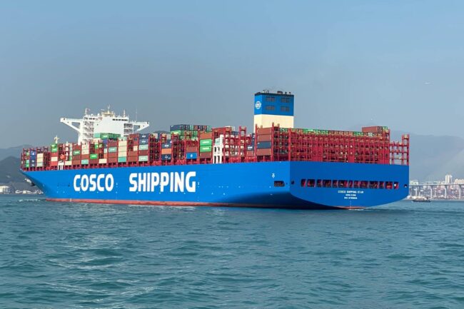A large COSCO container ship sailing on calm waters.